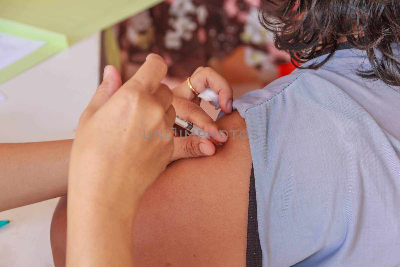 A young woman injecting hypodermic into  arm