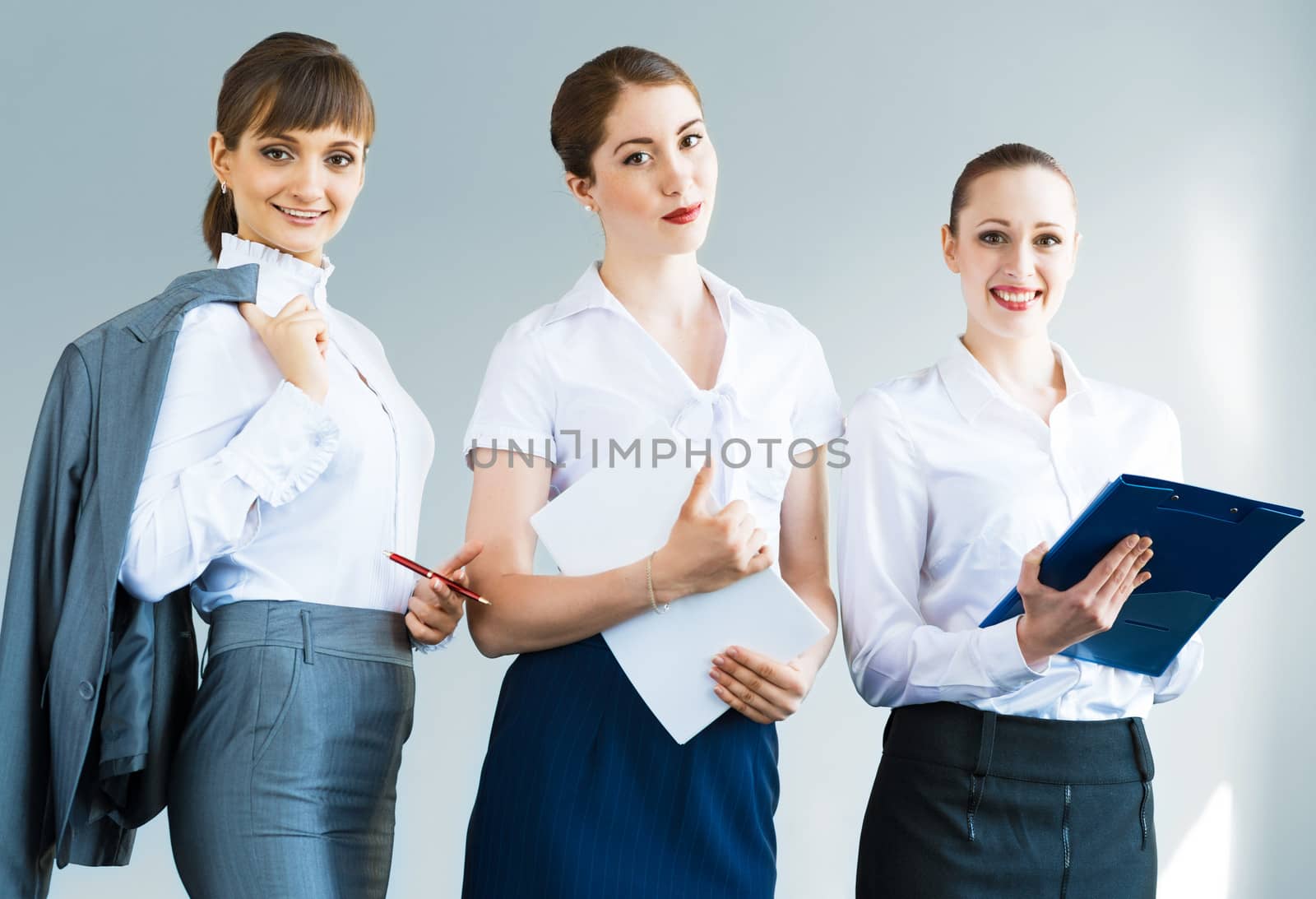 three business women standing in a row and smiling, teamwork in business