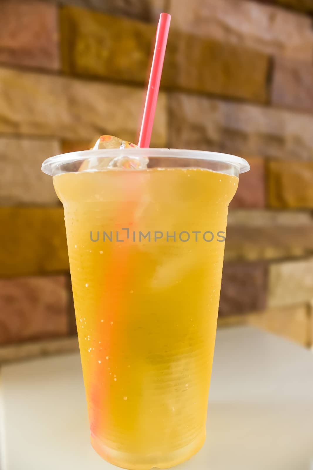 A glass filled to the top with ice tea and ice cubes.