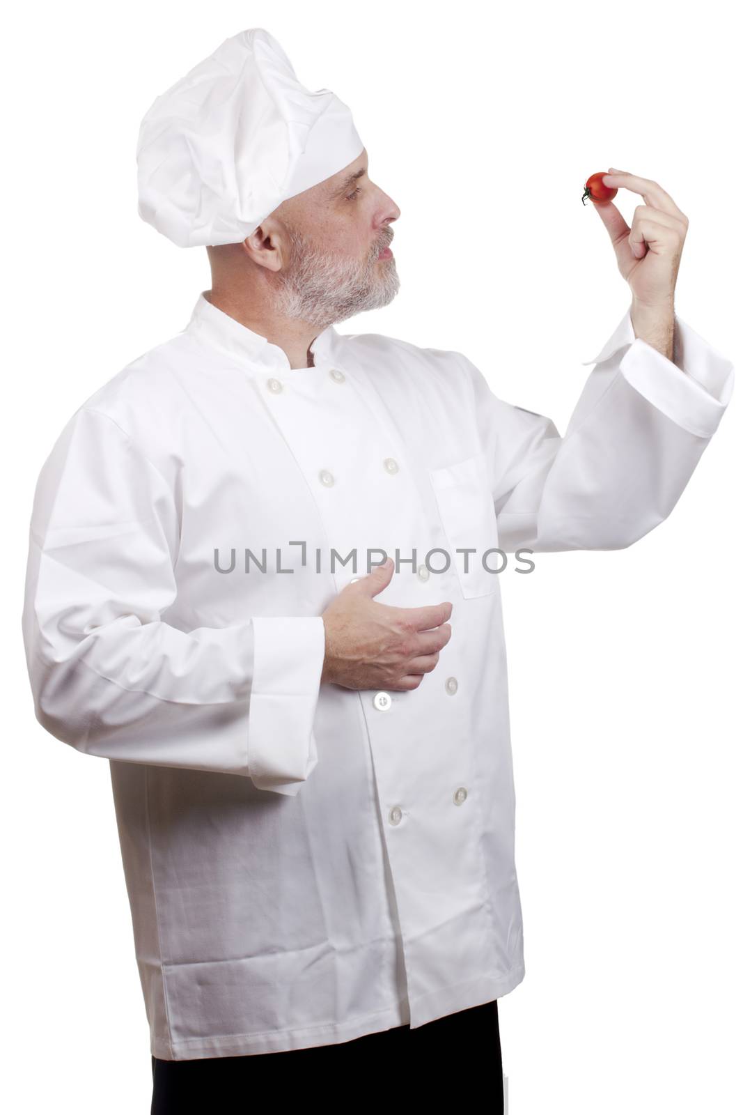 Cook holds a small tomato in hand.