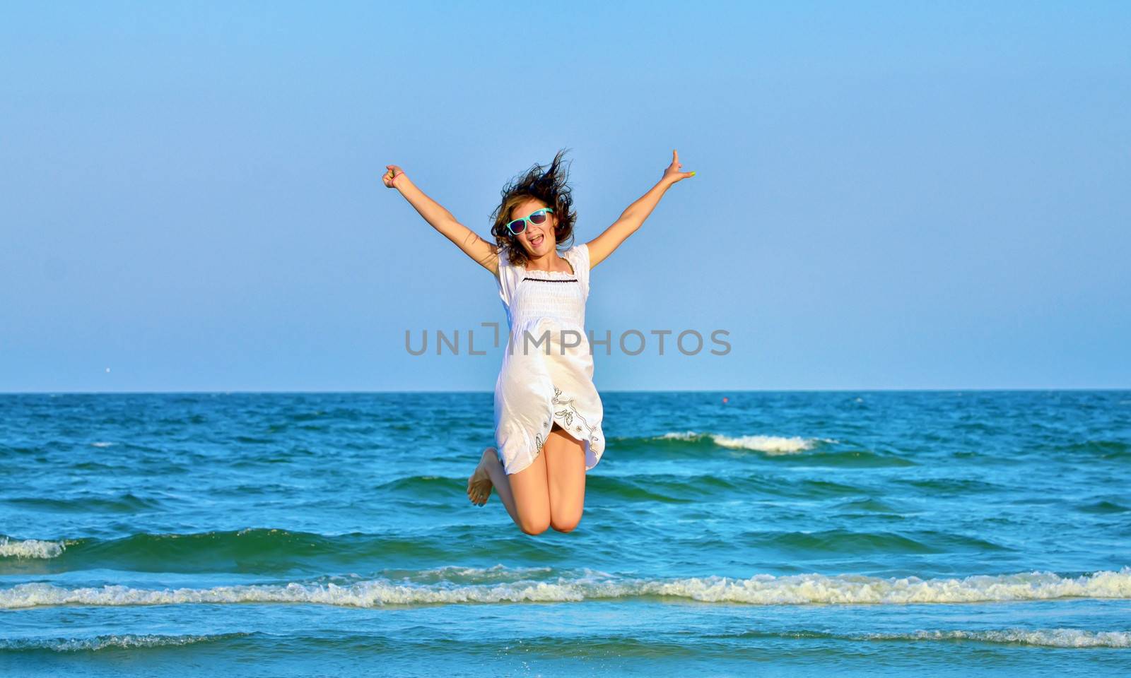Jumping happy girl on the beach by mady70