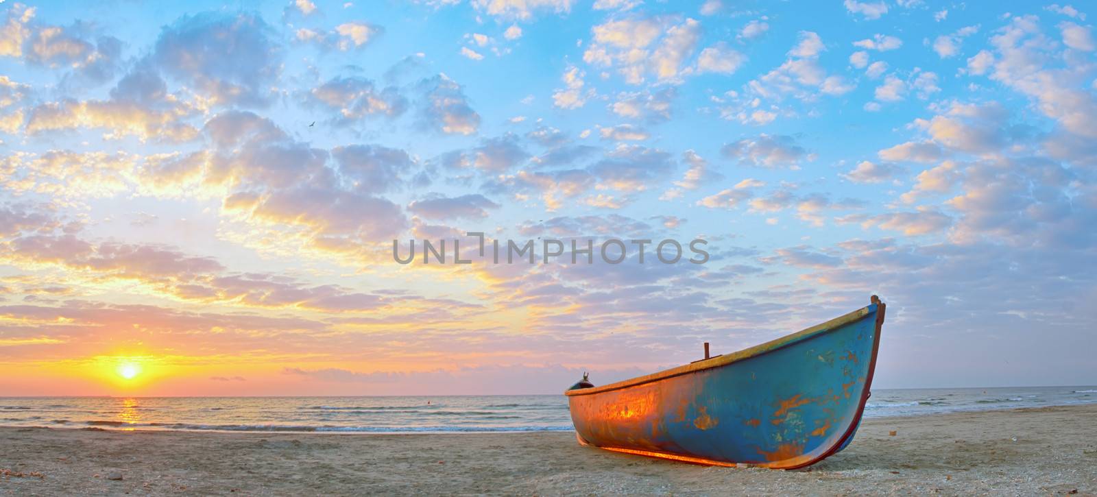 Fishing boat and sunrise on Black Sea beach