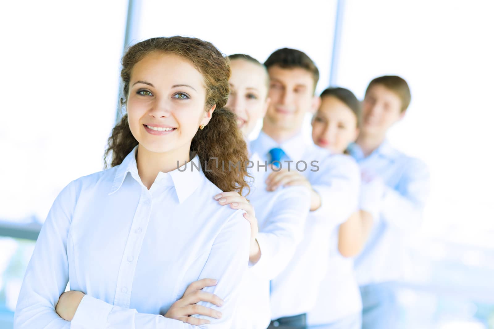 portrait of a young business woman standing in line with colleagues, concept of teamwork