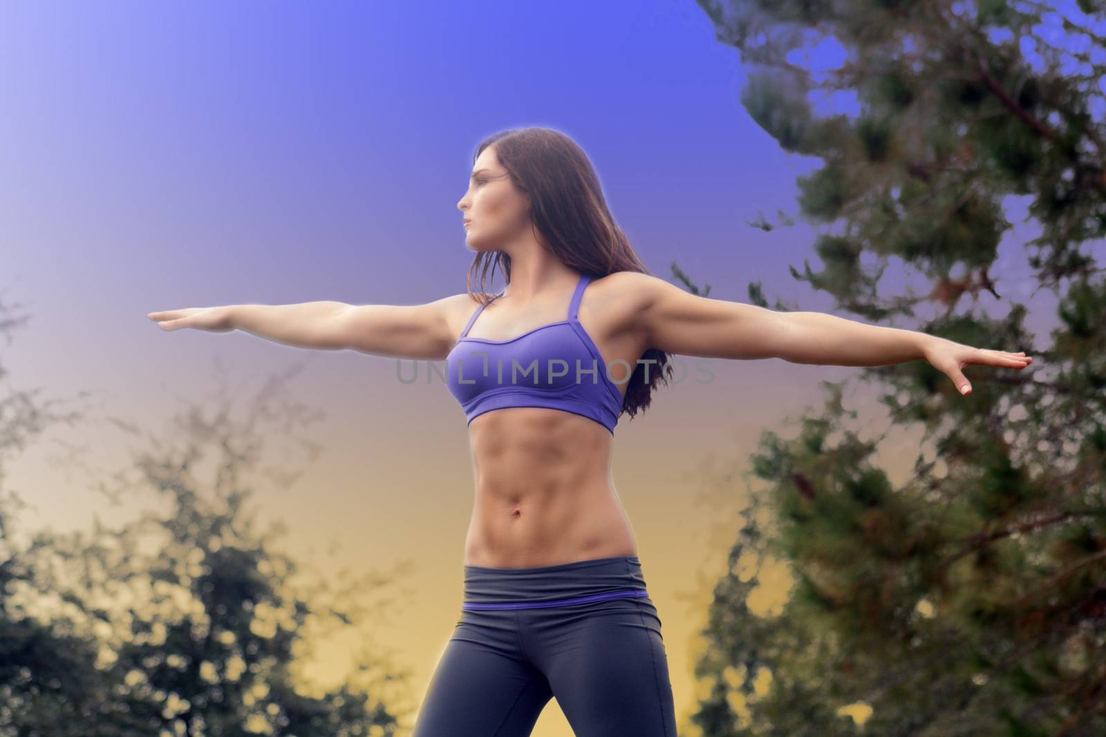 A lovely young brunette athlete stretches bilaterally outdoors, displaying her remarkable abs.