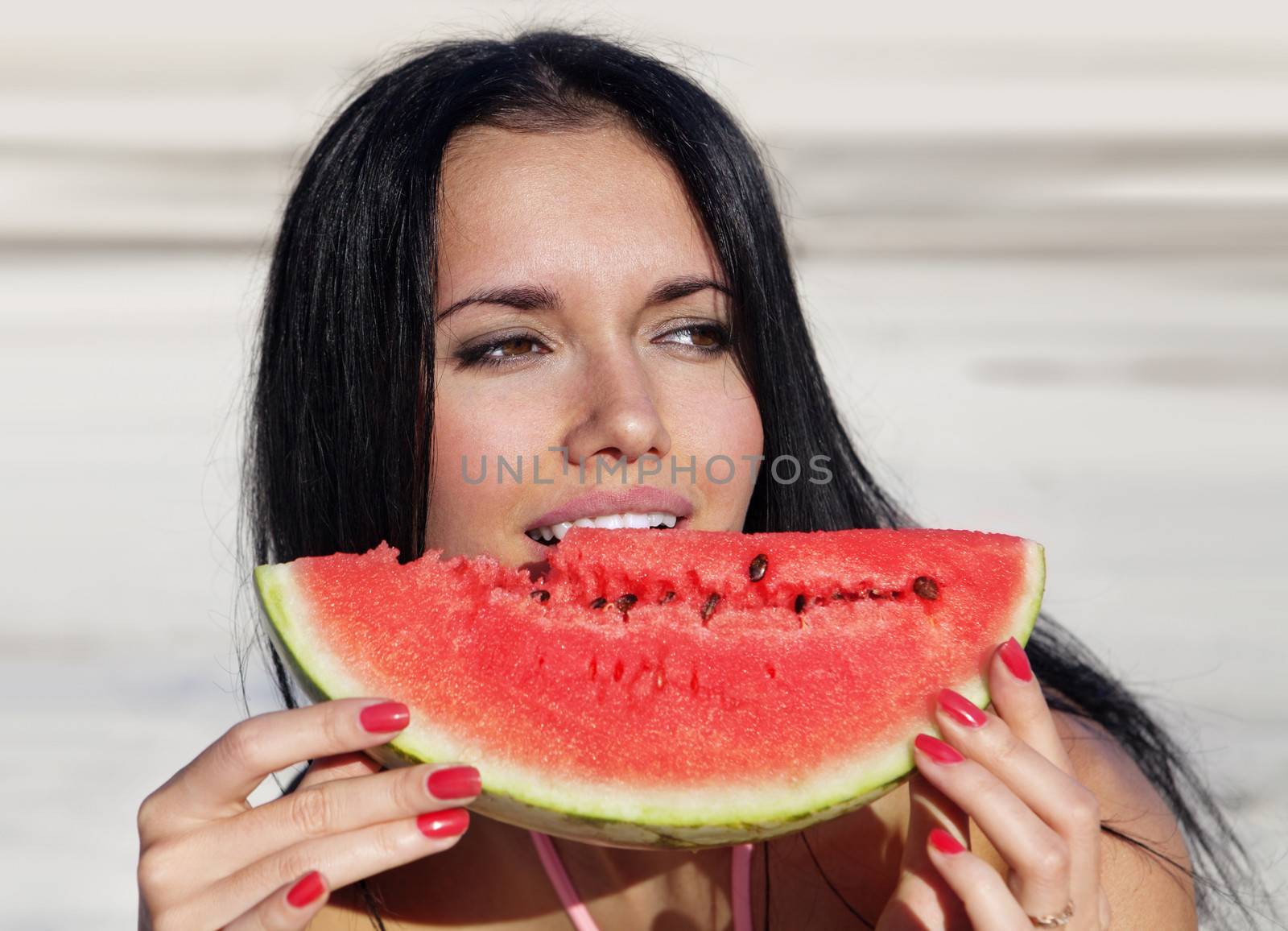 the happy girl eats a slice of ripe water-melon