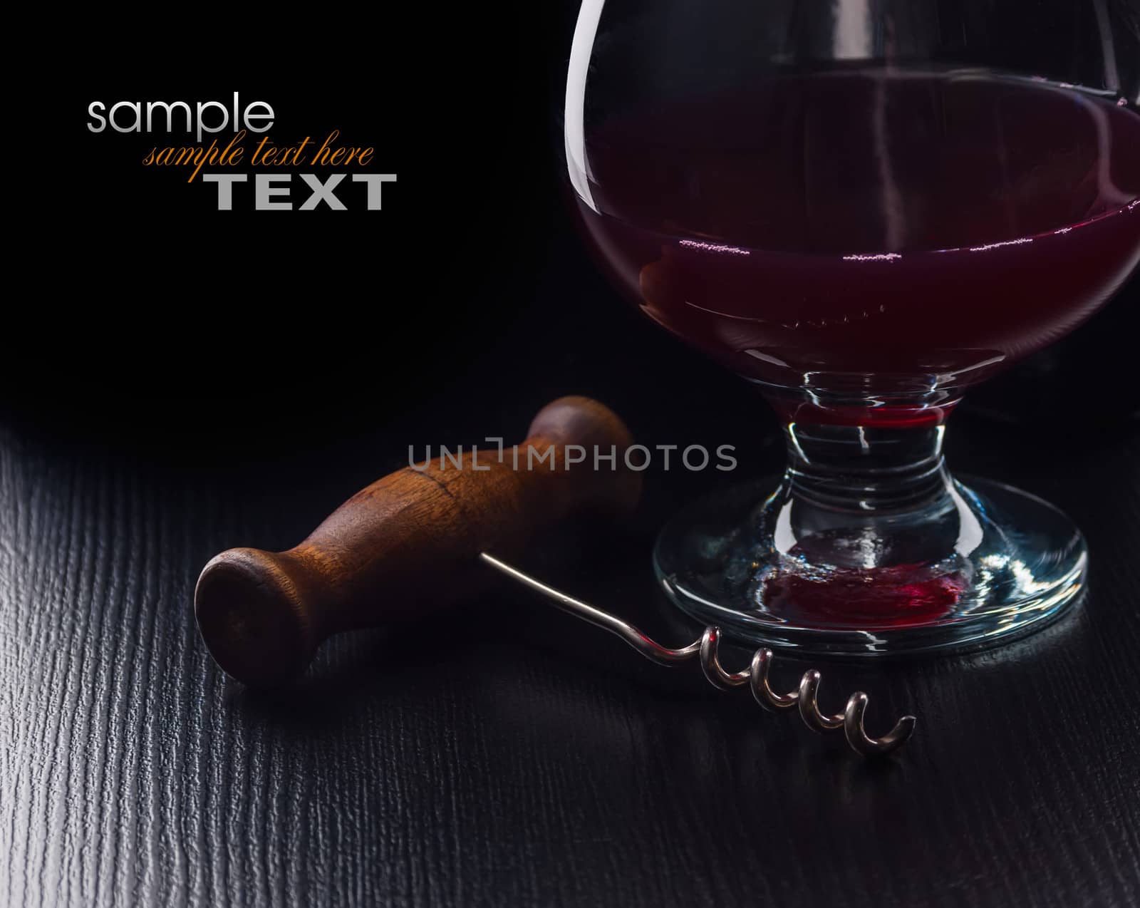 glass of wine and a corkscrew on a black table by oleg_zhukov