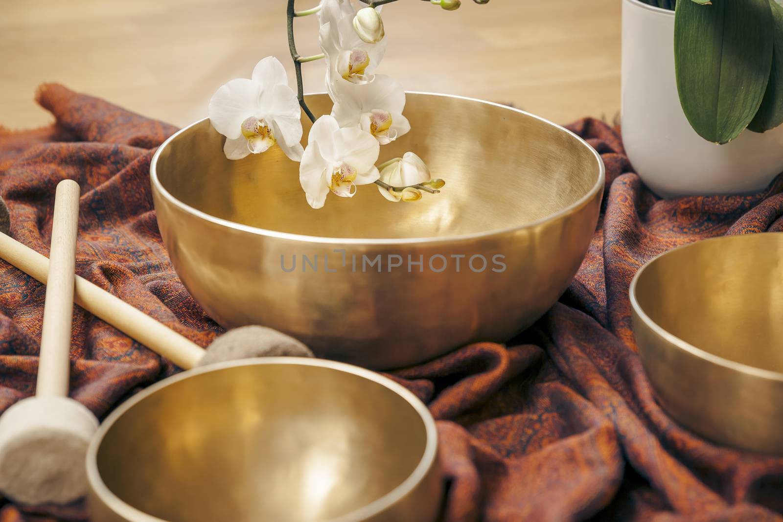 An image of some singing bowls and a white orchid