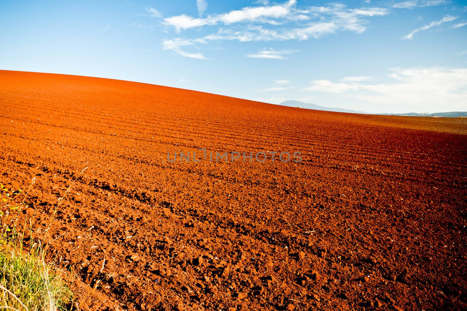 Red earth in newly turned and ploughed agricultural fields under a blue summer sky in a beautiful Australian landscape