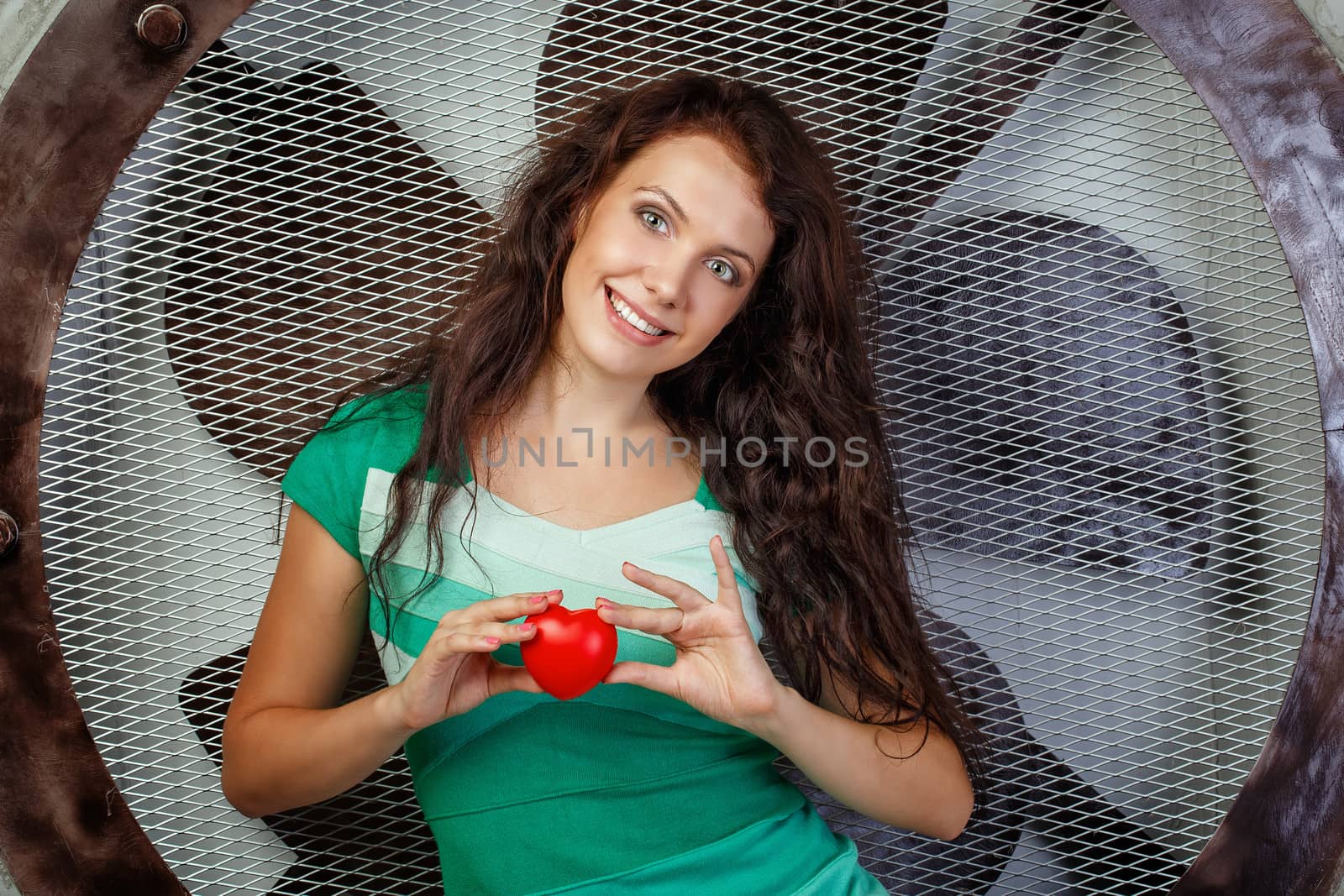 Beautiful girl in a dress holding a heart, photographed in the studio