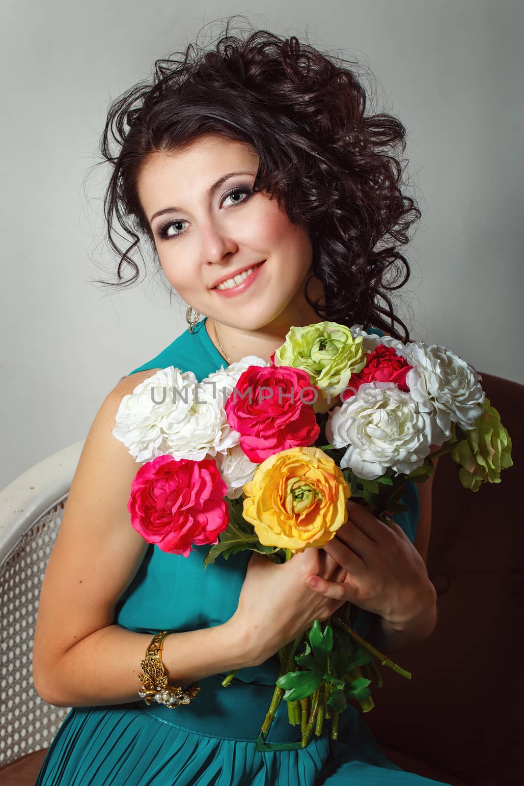 Girl in a dress holding a bouquet of flowers. Photographed in the studio