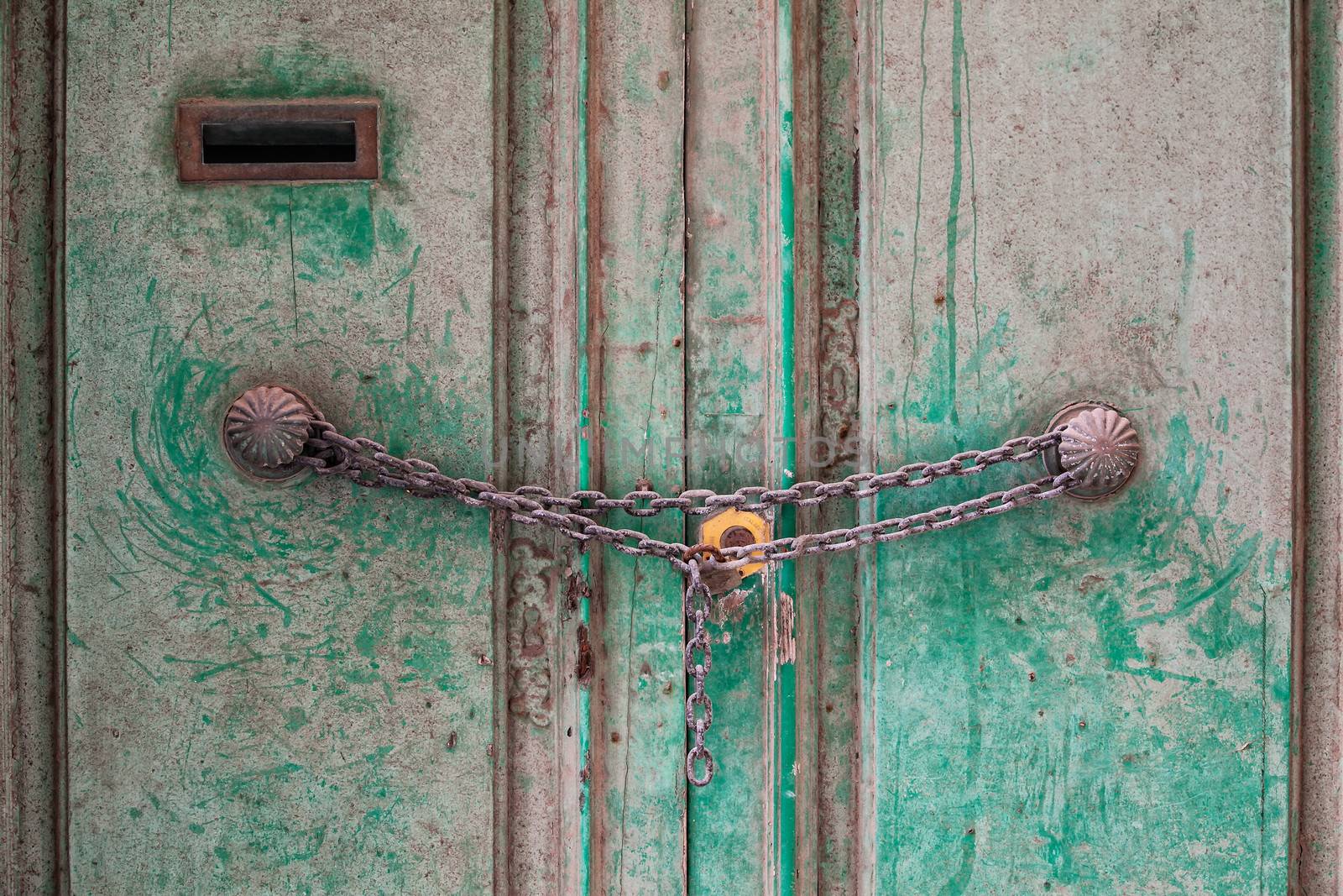 An old traditional door locked with chain and padlock.