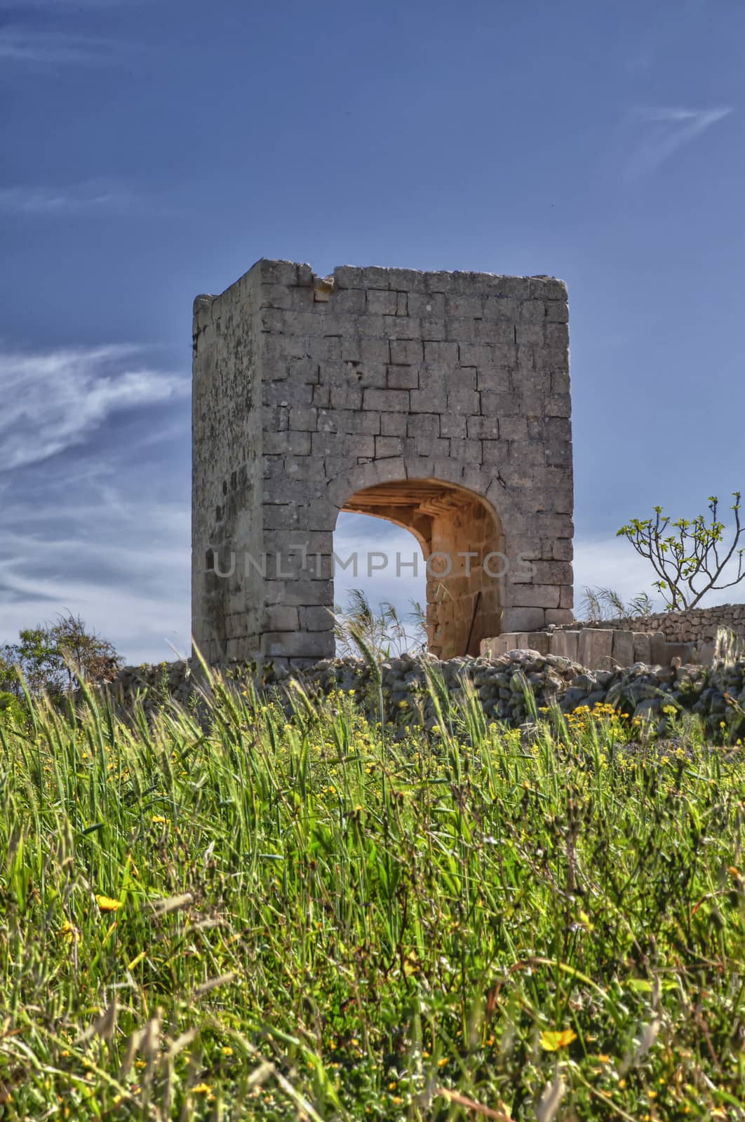 An elevated birthing chamber in the Maltese countryside, with an underlying arched underpass.