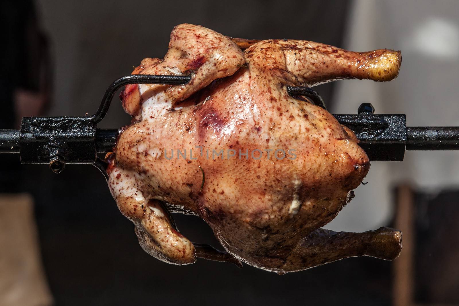 Whole chicken being roasted on an open fire