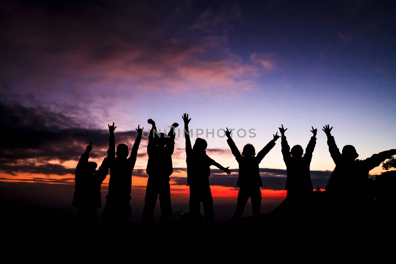 silhouette of group of friends standing in sunset  by jame_j@homail.com