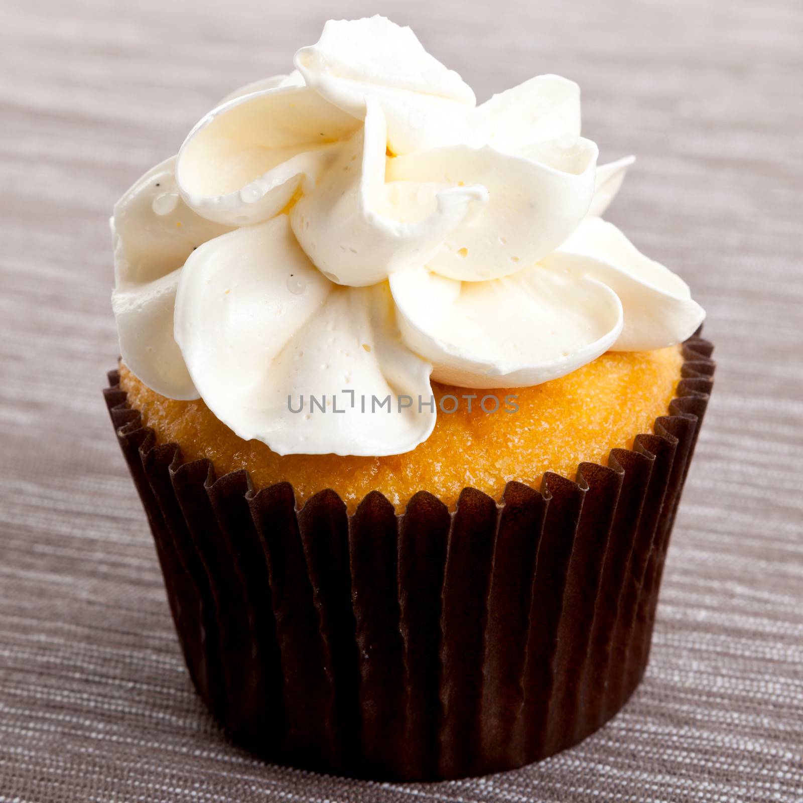 tasty sweet homemade cupcakes with cream on table by juniart
