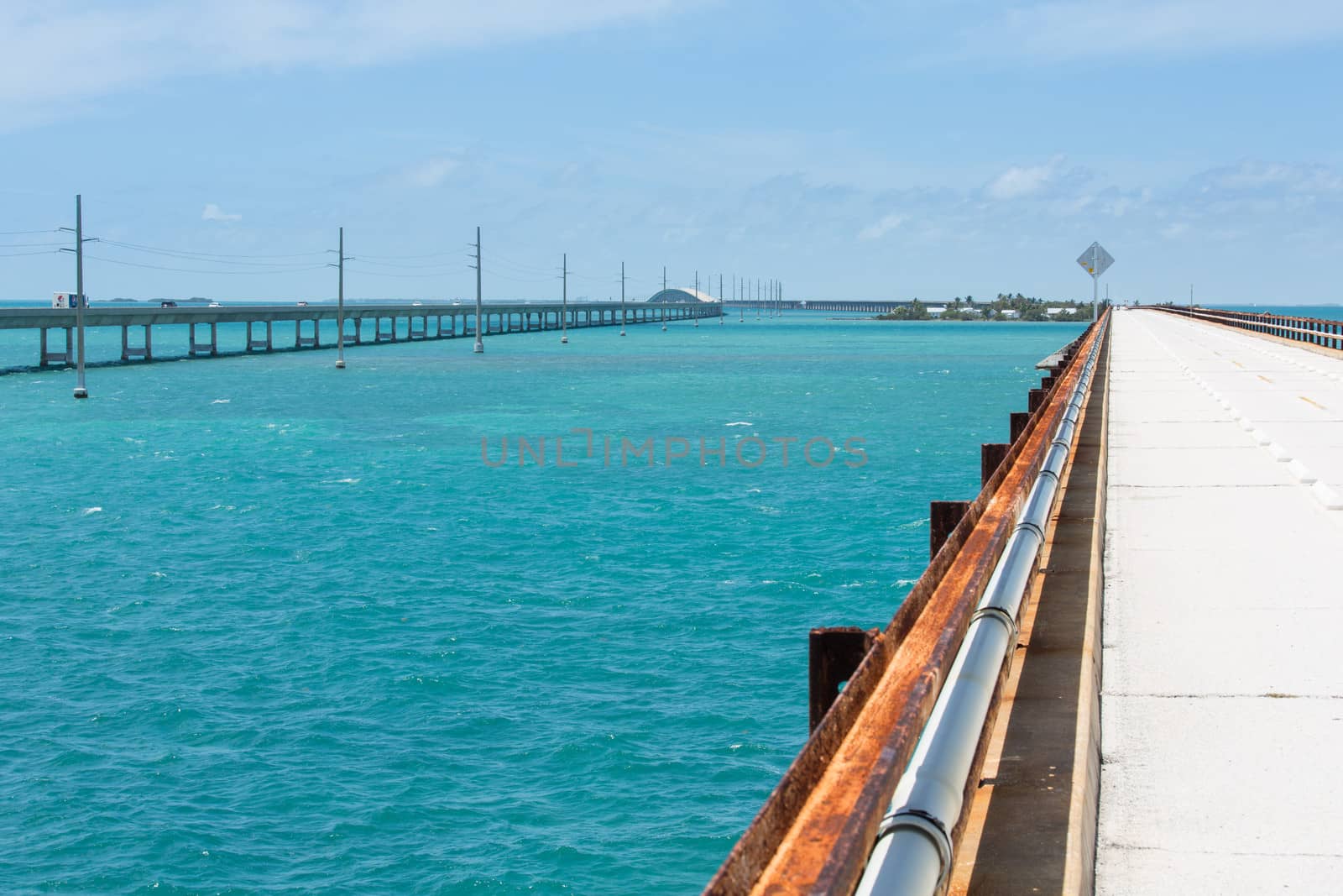 This image shows the orginal seven mile bridge and the current highway. Pigeon Key is in the background.