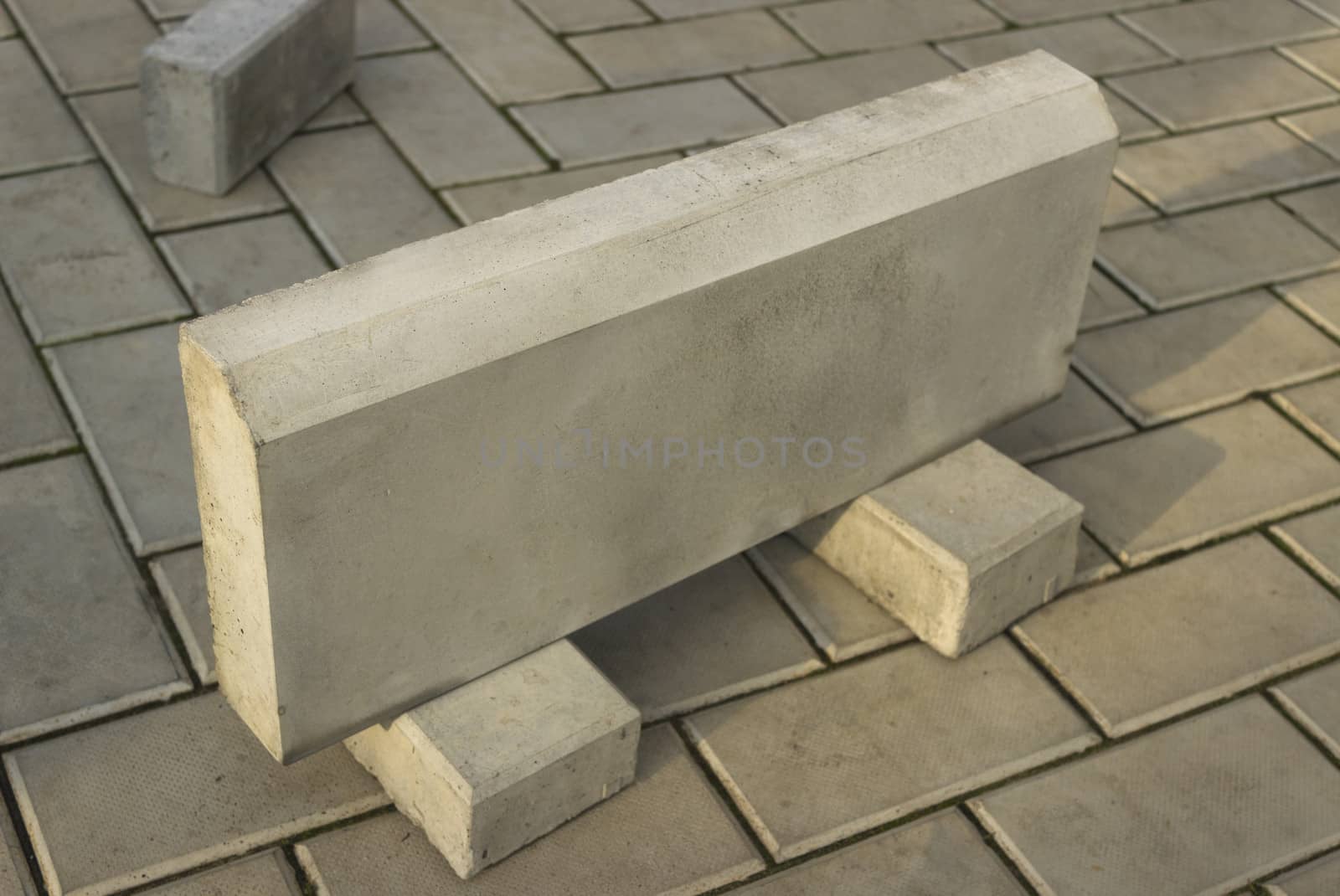One large curb stone is made of concrete, on the stone floor