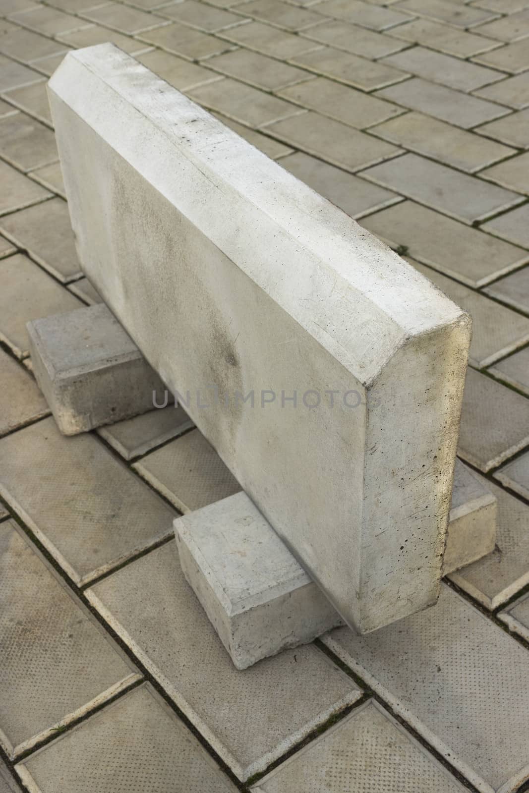 Large curb stone is made of concrete, on the stone floor