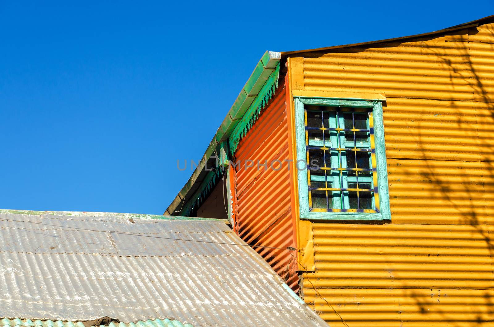 Old orange building set against a blue sky in La Boca neighborhood of Buenos Aires