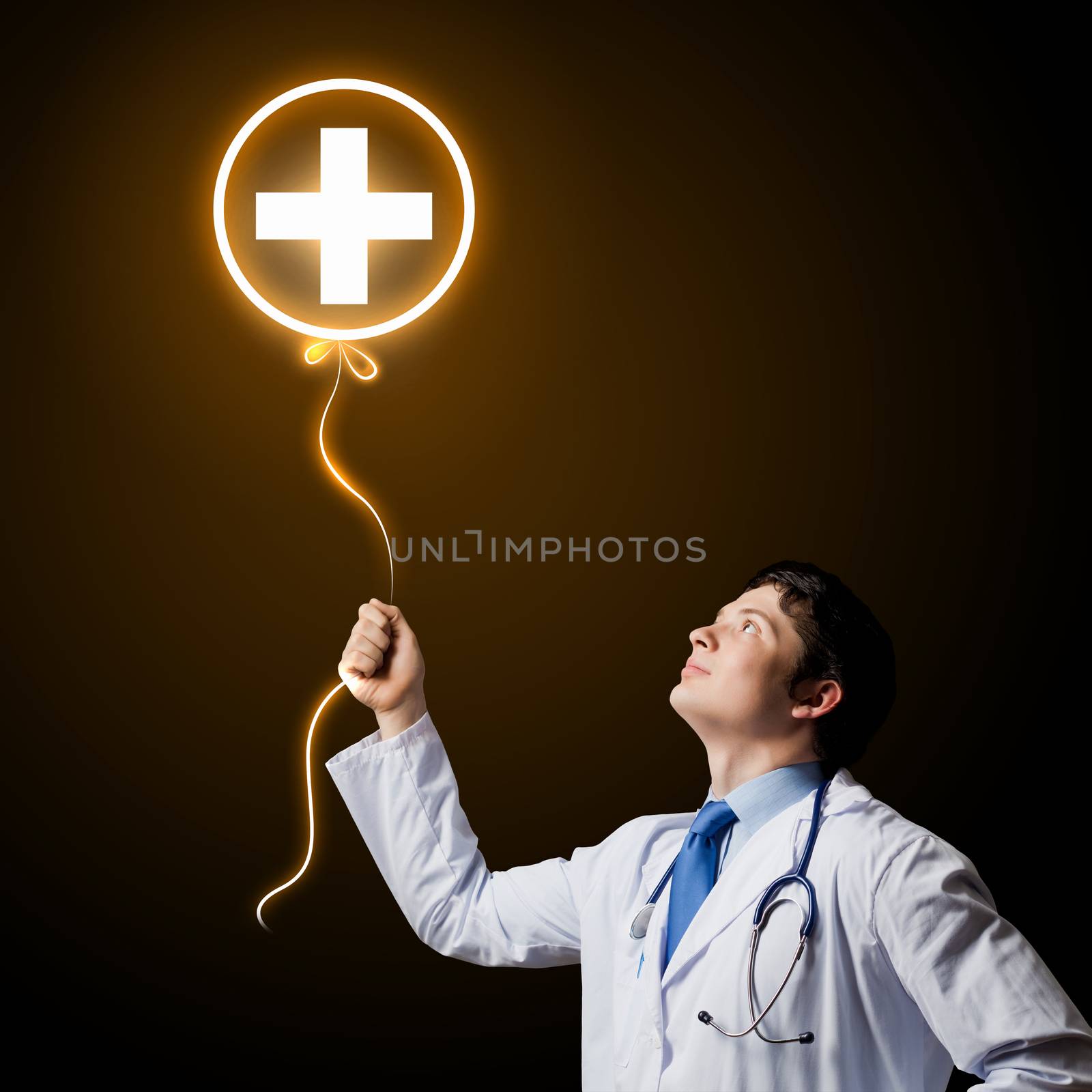 Young male doctor holding balloon with medical sign