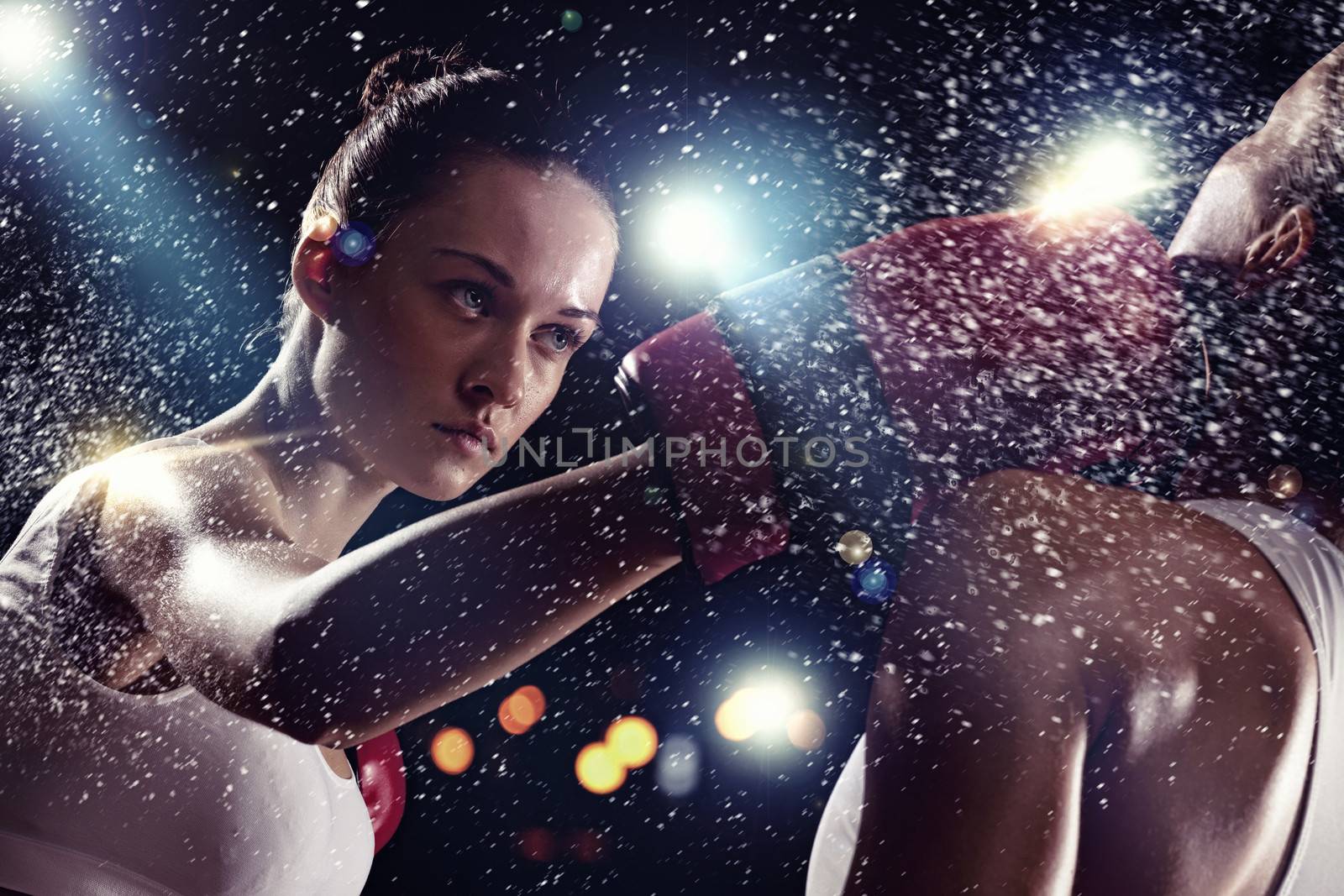 Two young pretty women boxing standing against flashes background