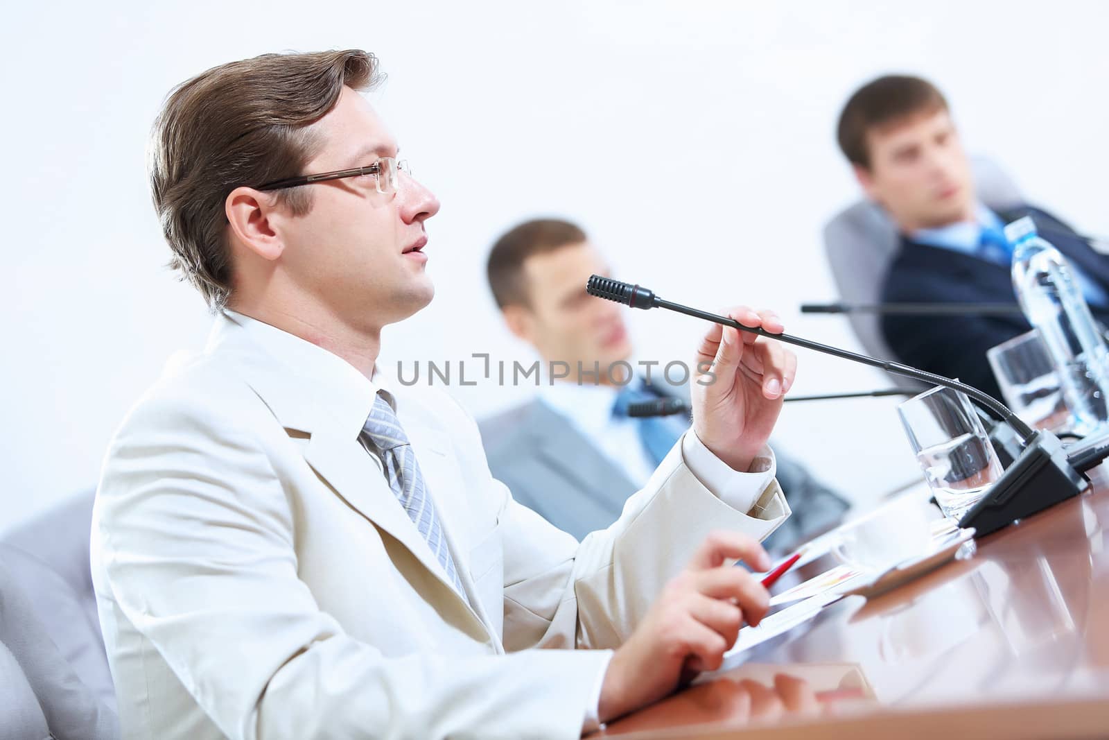 Image of three businesspeople at table at conference