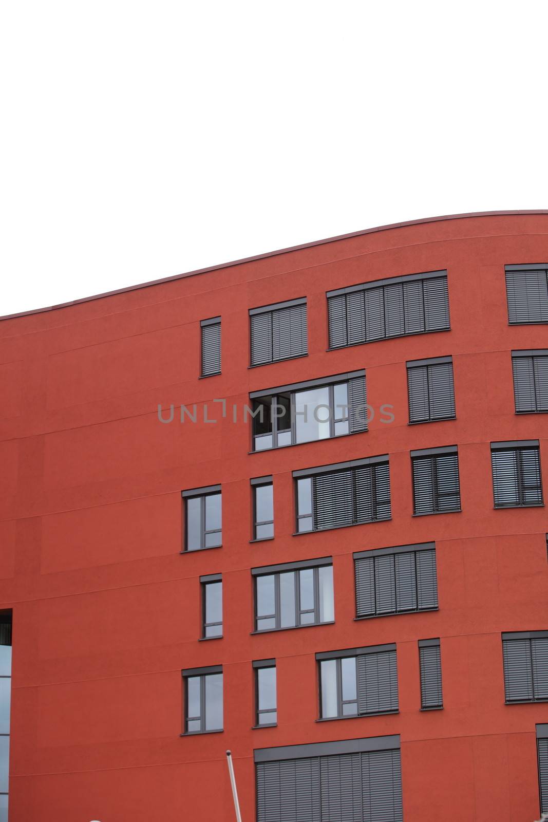 Exterior of a red commercial building with windows and a flat roof with copyspace