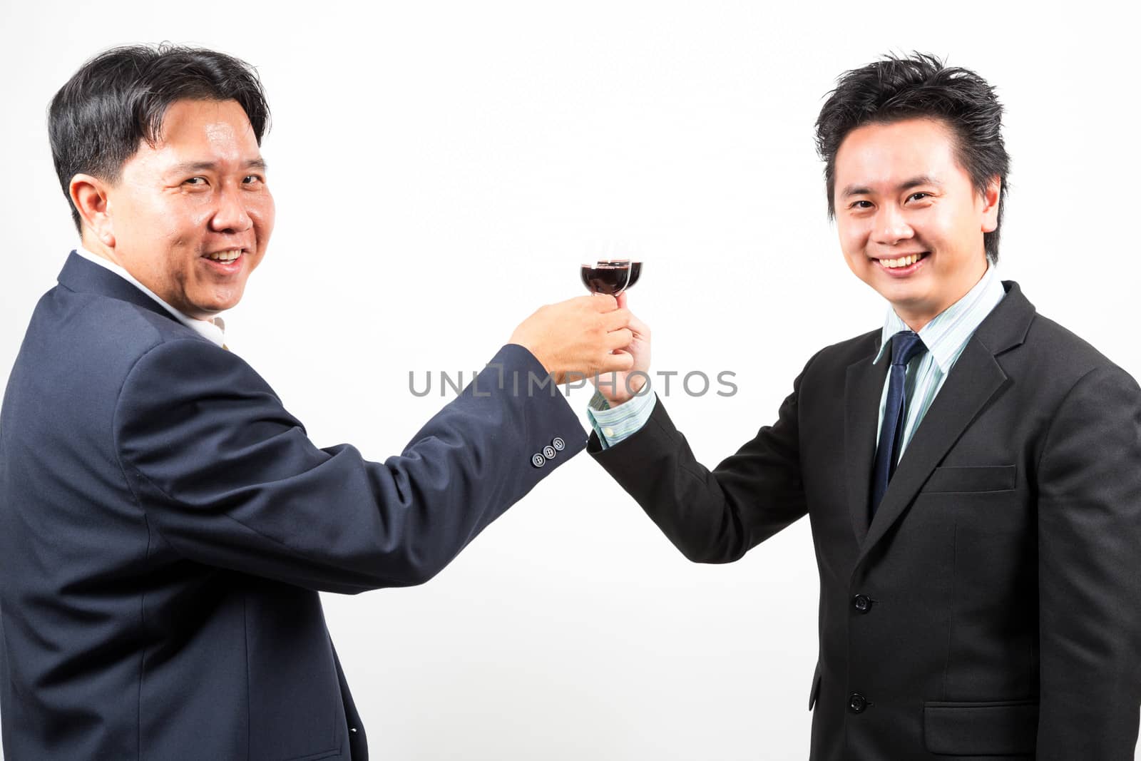 Two happy businessmen cheering up with flutes of wine