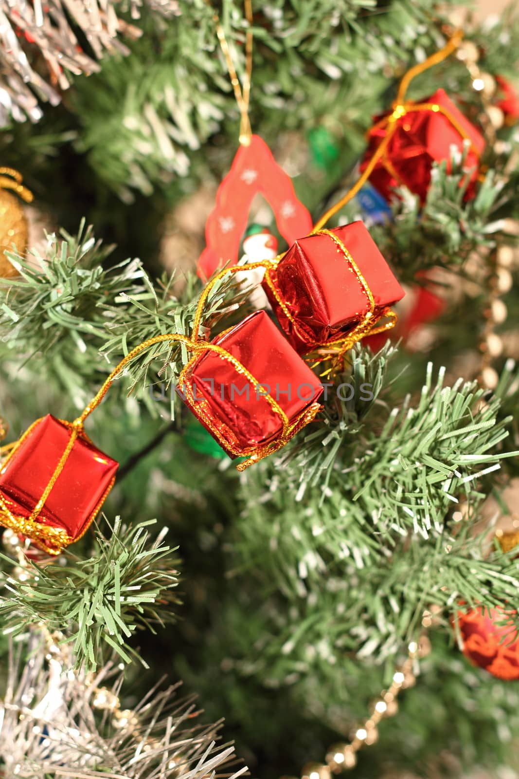 closeup of red decorations in presents shape on the christmas tree