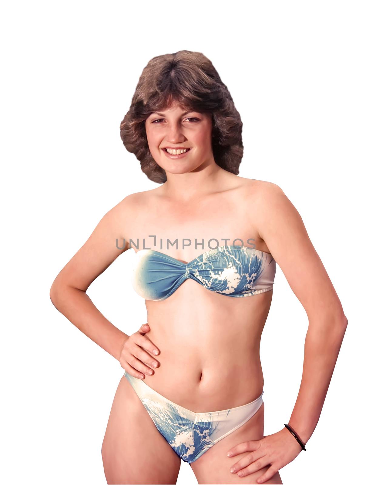 Teenage girl with brown shoulder length hair wearing a fashionable blue and white two piece swimsuit, standing confidently before a white background...includes clipping path