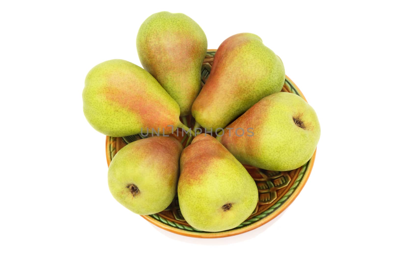 Large ripe yellow pears on a ceramic plate. Presented on a white background.