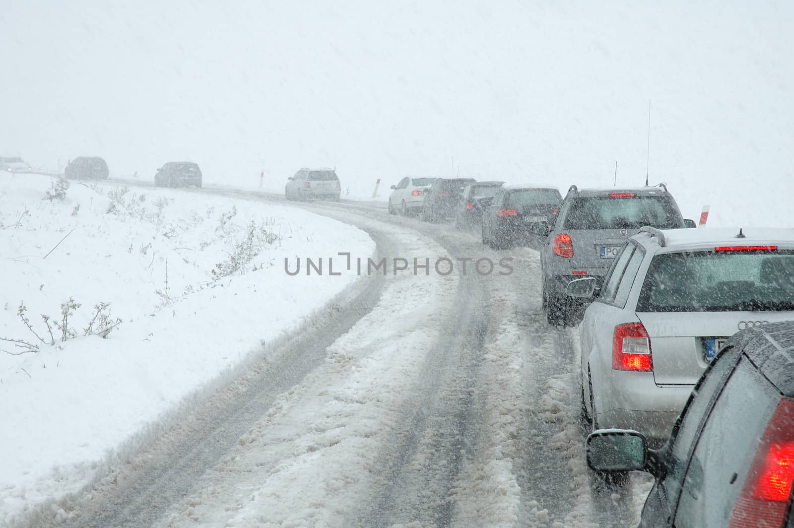 Traffic jam in heavy snowfall on mountain road by janhetman