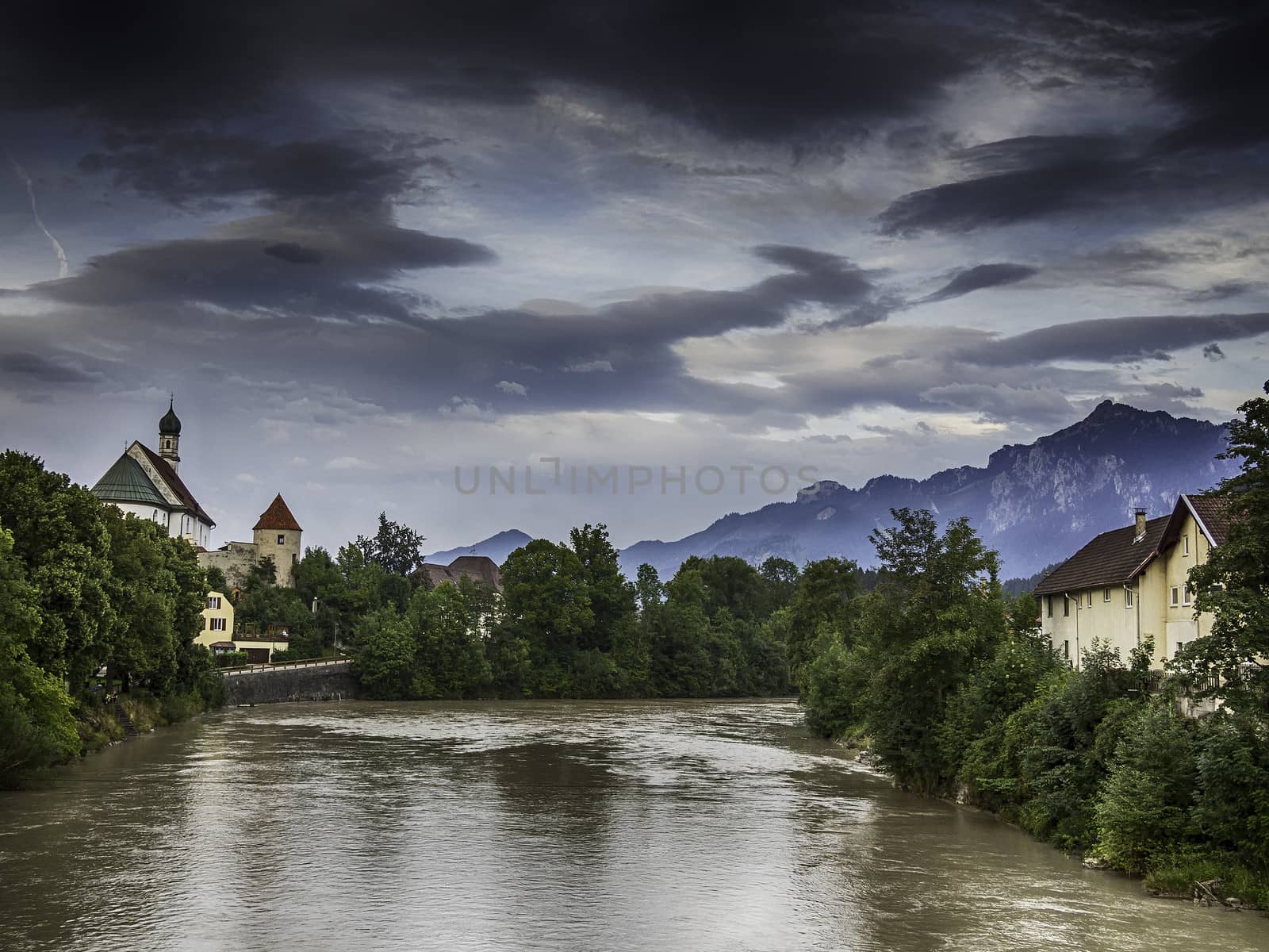 Picture of river Lech in Fussen with historic church and alps in Germany