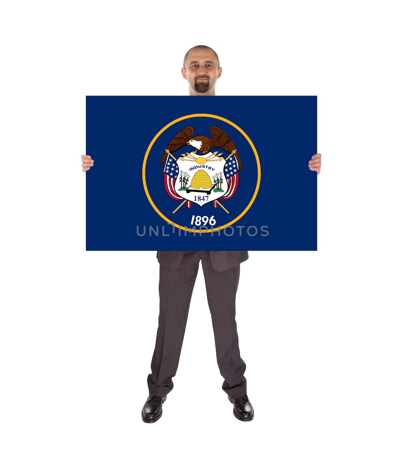 Smiling businessman holding a big card, flag of Utah, isolated on white