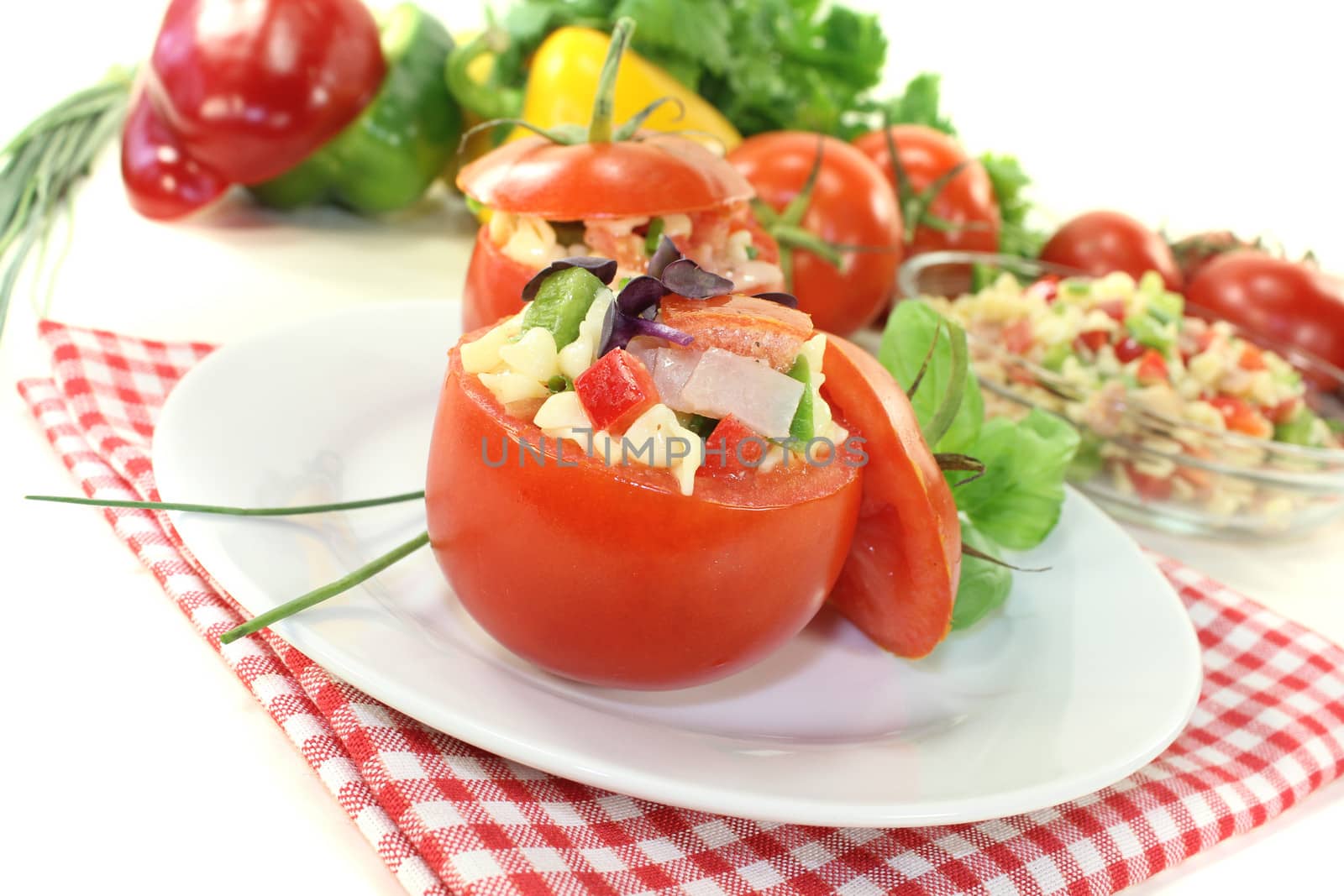 stuffed tomatoes with pasta salad on a light background