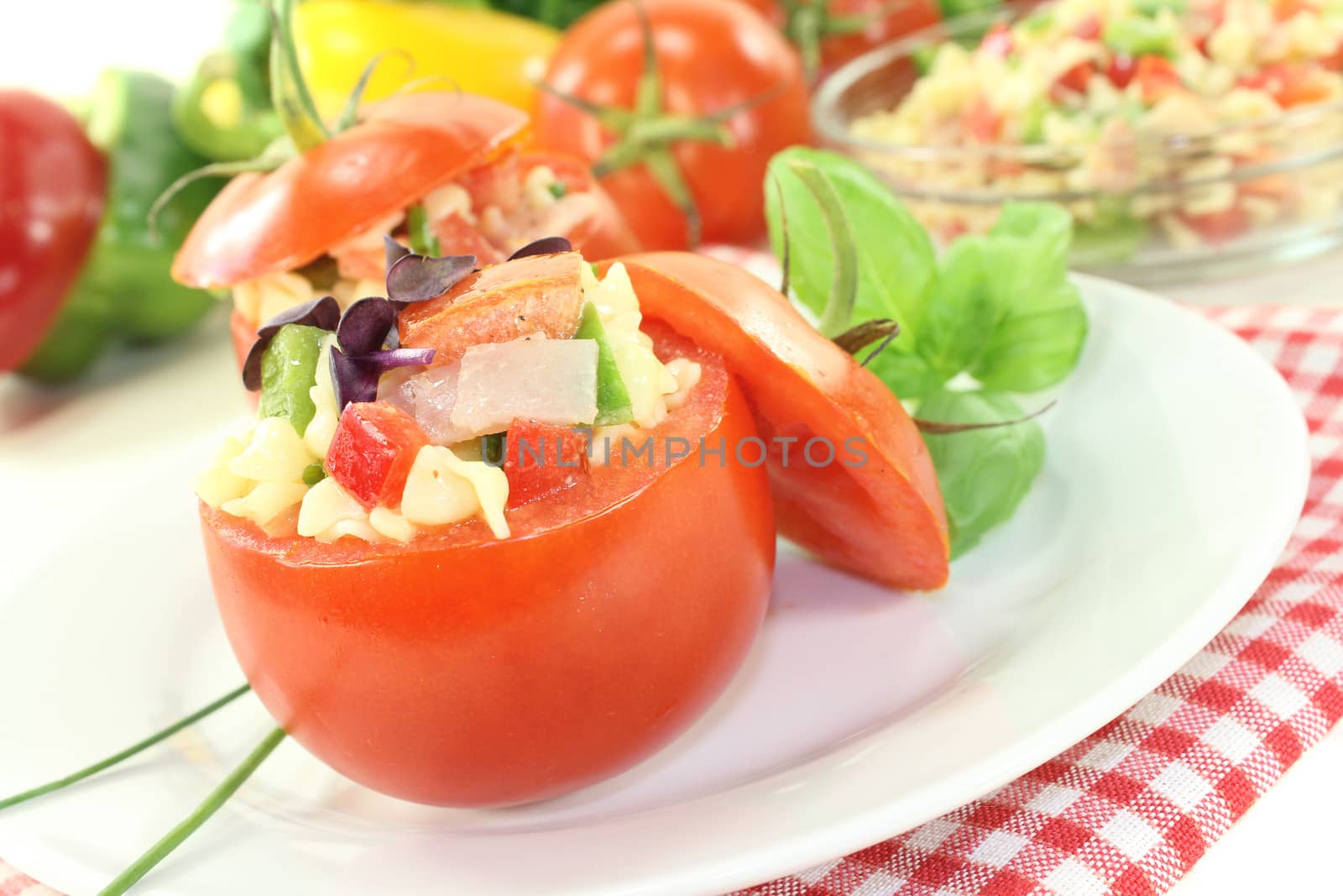 stuffed pasta salad with tomatoes and chives on a light background