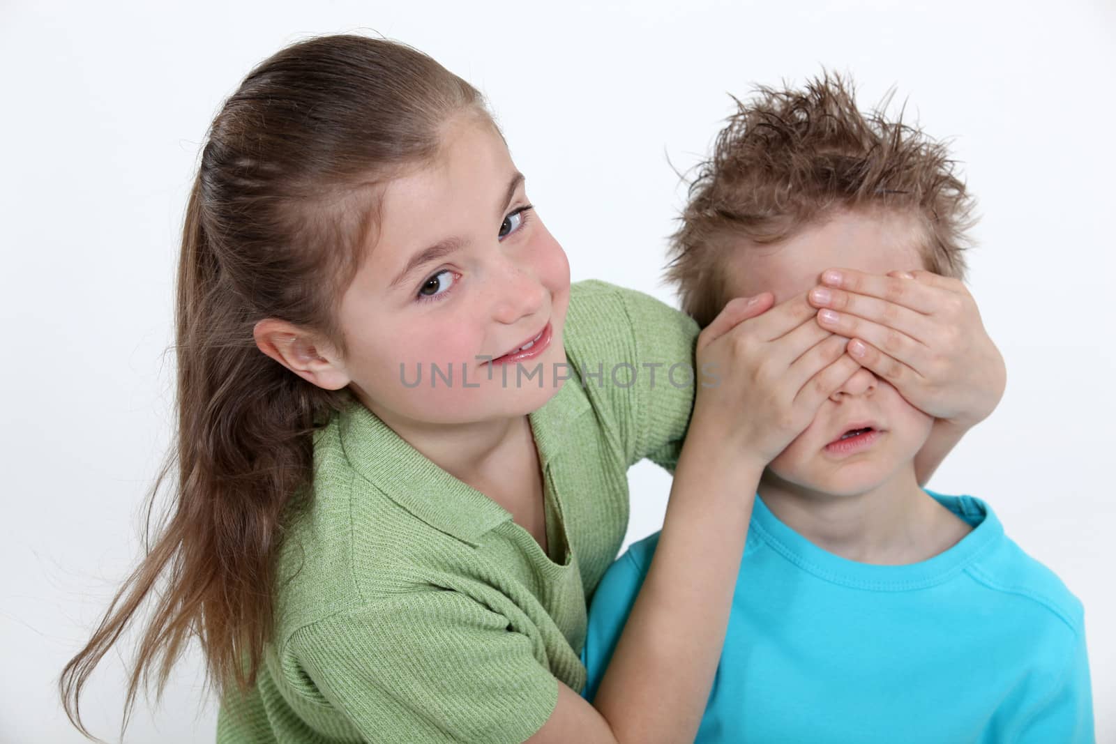 sister placing hands over brother's eyes