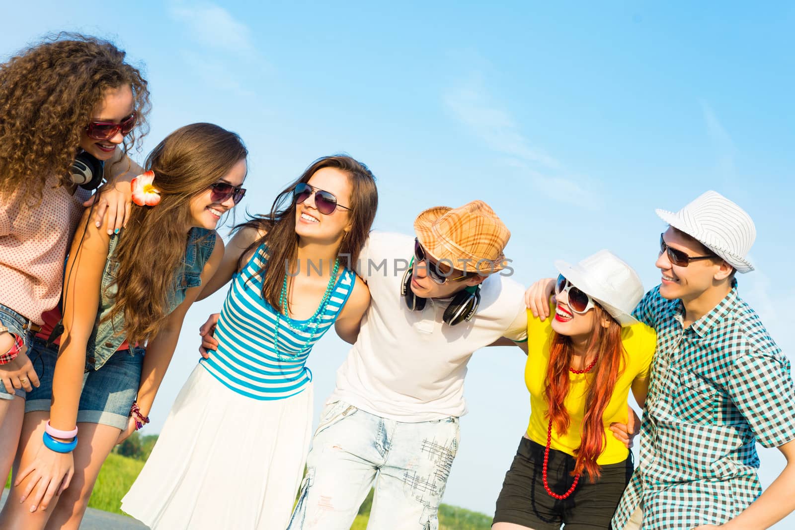 group of young people wearing sunglasses and hats hugging and standing in a row, spending time with friends