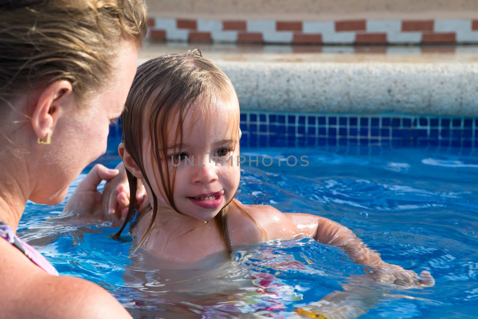 Mother and Daughter Playful in the Pool by coskun