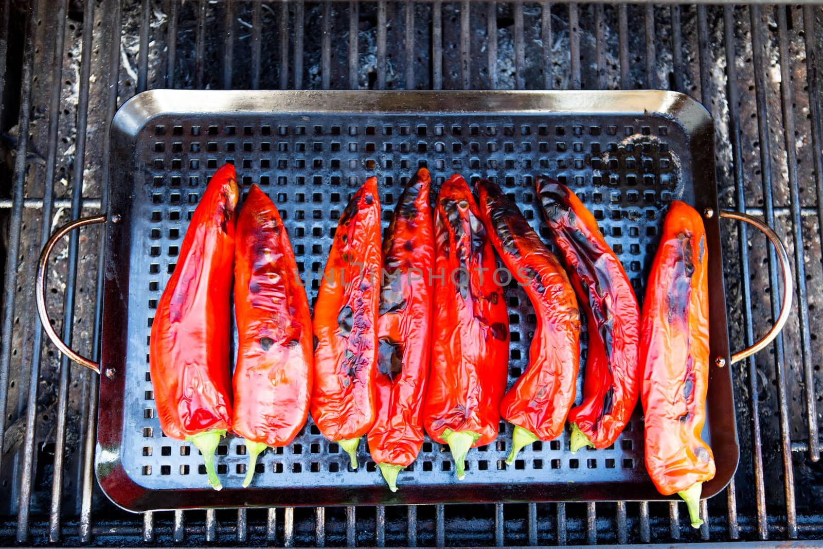 Eight pieces of grilled chili placed on a rectangular tray in the barbecue.