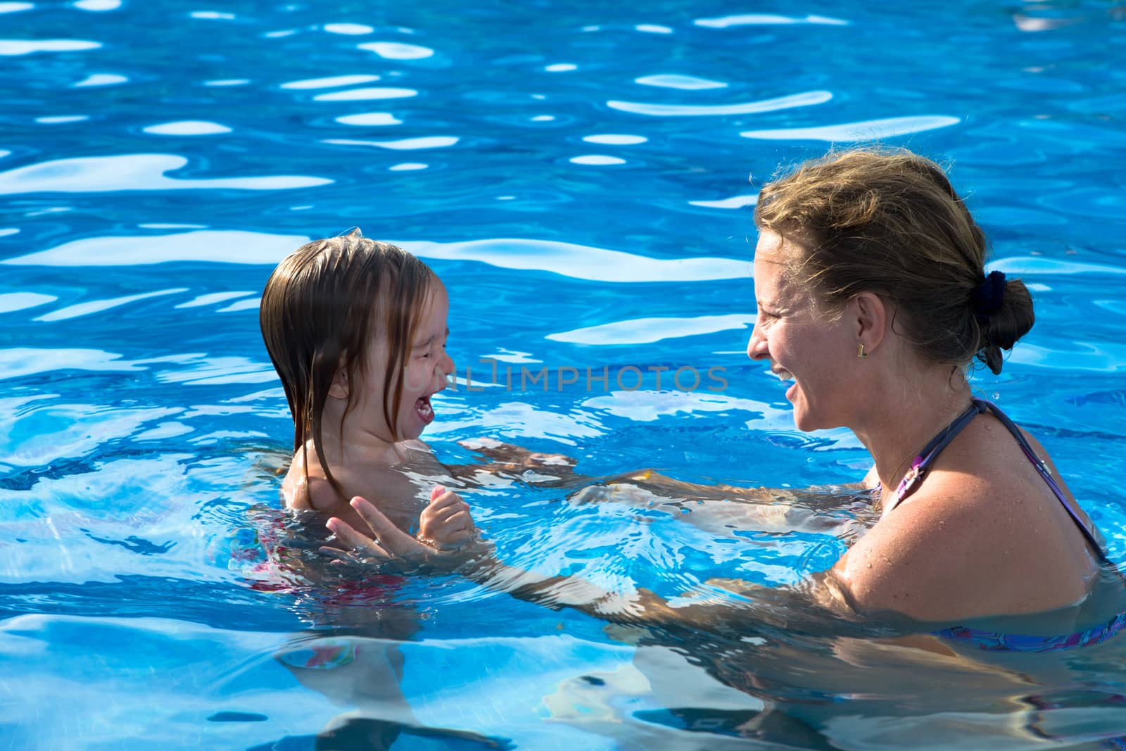 Mother teaching her daughter how to swimm by how not to scare of water