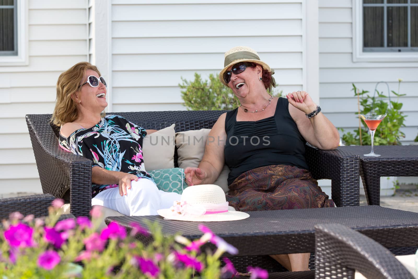 Couple women having happy conversations outside at the patio.