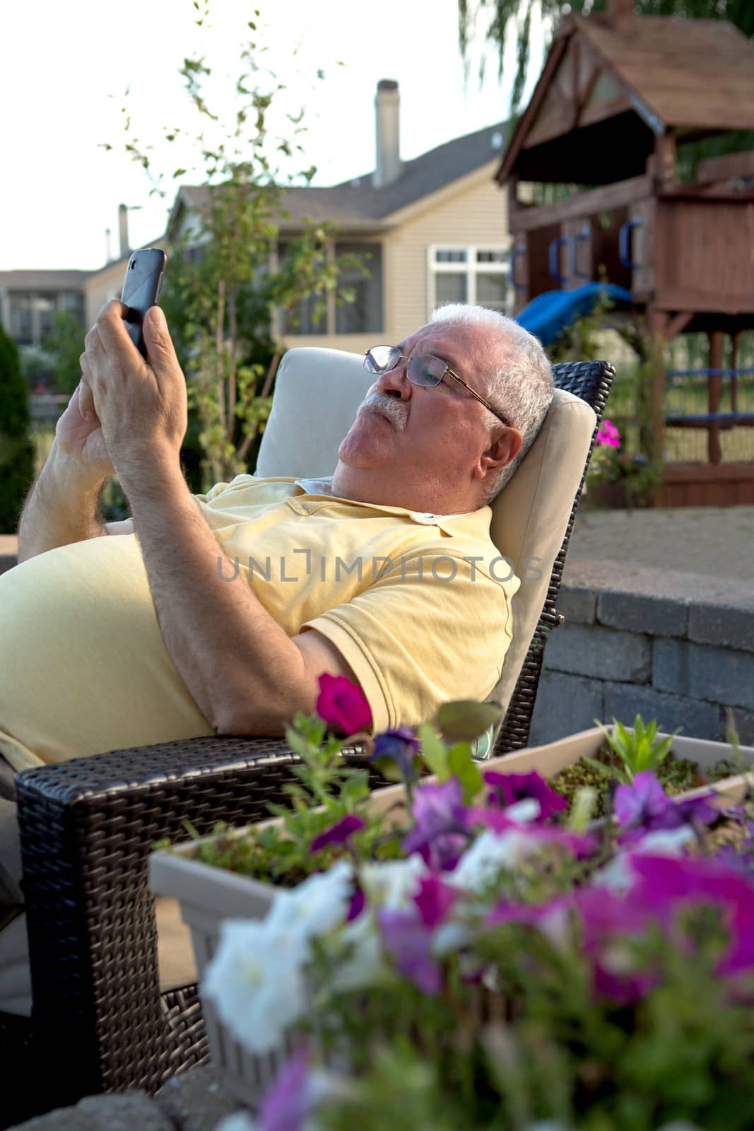An old man using a cellular phone.