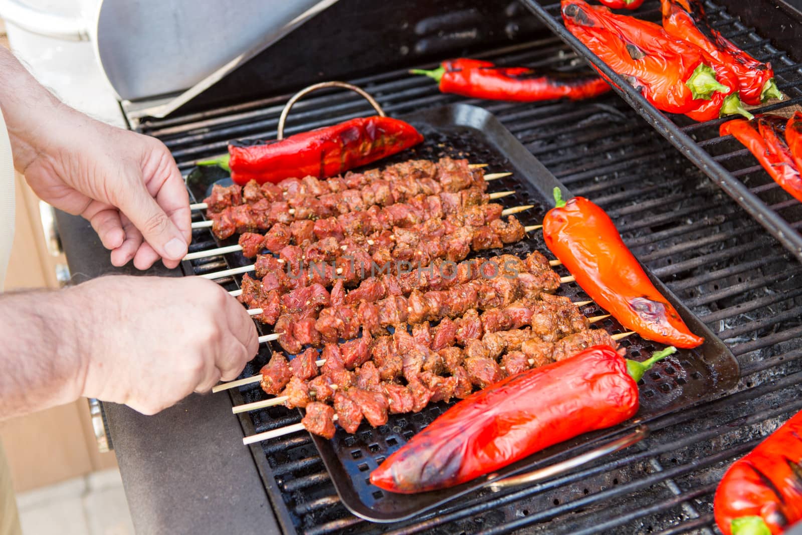 Ten pieces of barbecue and red chilies being grilled.