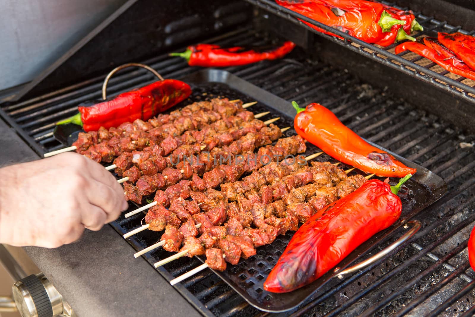 Ten pieces of barbecue and 4 pieces of chili being grilled.