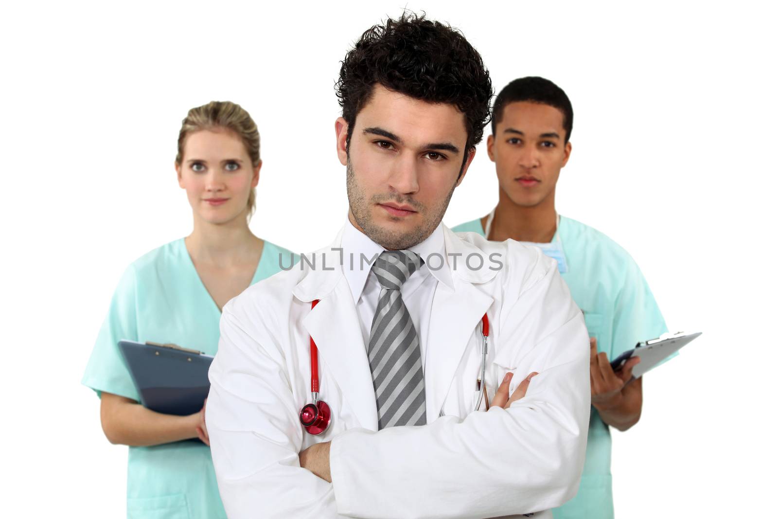 young doctor standing cross-armed with male and female nurses in background