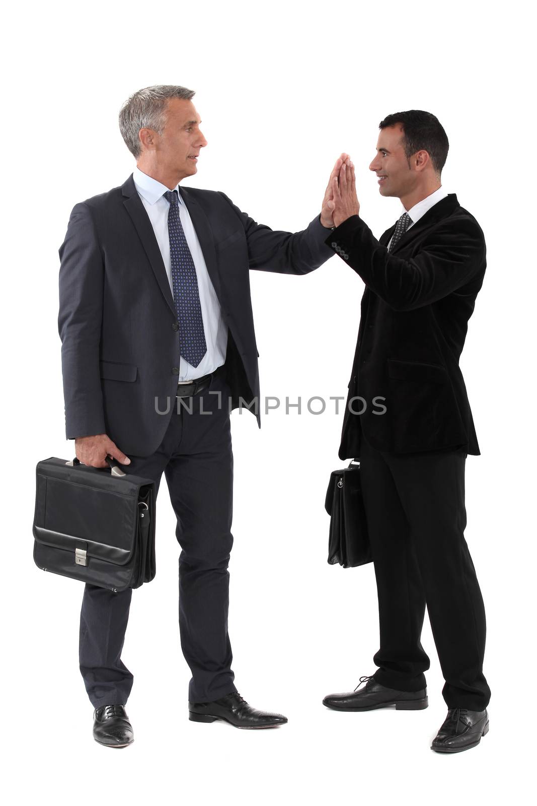 Two businessmen giving each other high-five by phovoir