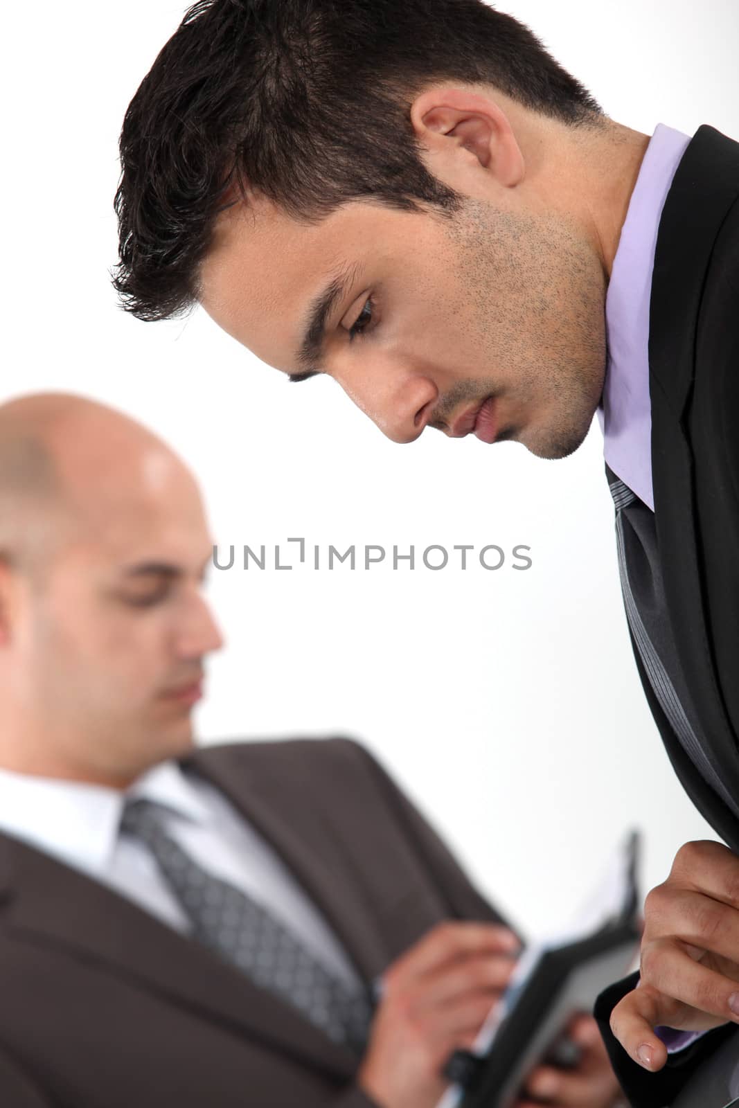Two businessmen checking their schedules