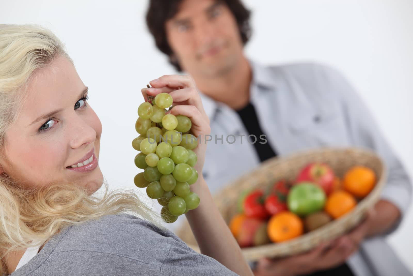 Couple with a basket of fruit by phovoir