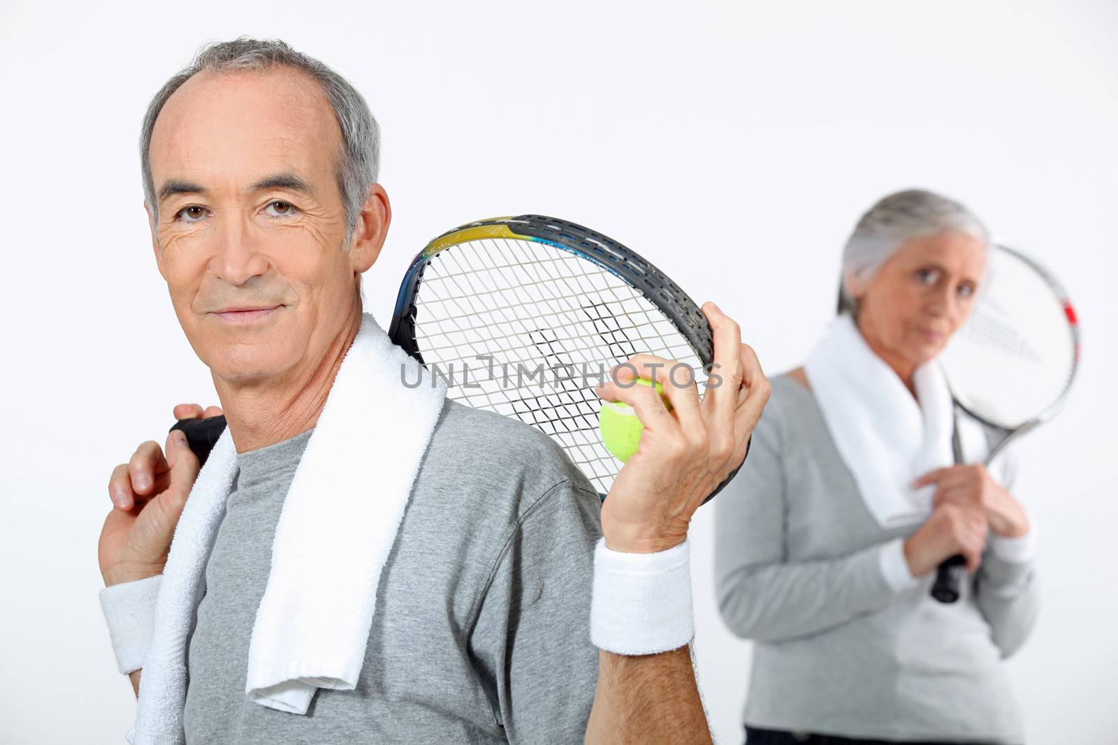 Older couple with tennis rackets